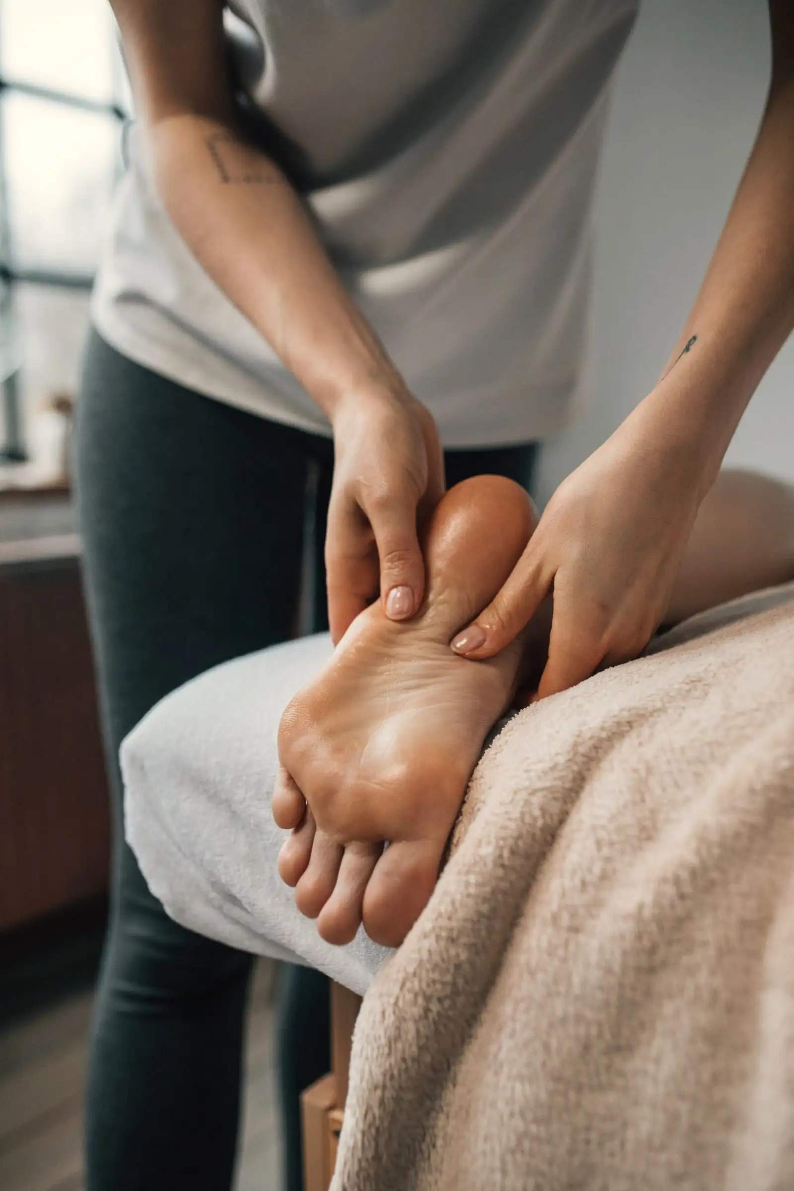 Palce maséra tlačia na reflexné body na chodidle